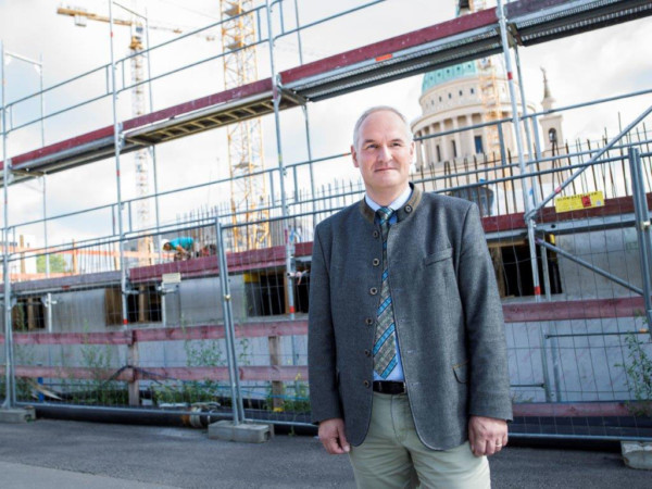 Bernd Rubelt steht vor einer Baustelle.