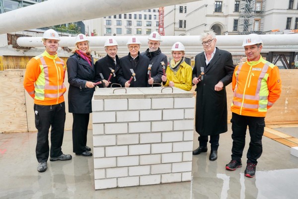 6 Männer und zwei Frauen stehen um den Grundstein des Anbaus für das Bundesratsgebäudes herum und führen die traditionellen Hammerschläge aus.