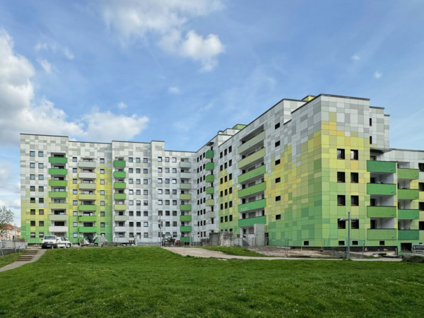 Citywohnpark in Duisburg: Die Fassade besteht aus Platten mit einem Farbverlauf von Grün- Gelb und Weißtönen.