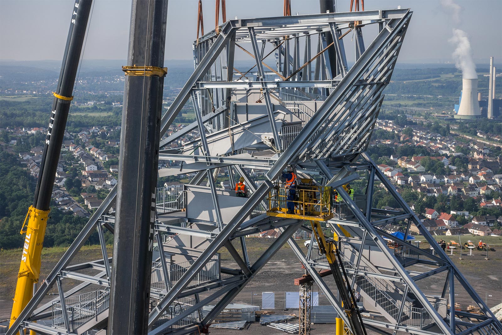 Das Profilbildvon Stahlbau Queck (Claus Queck GmbH) aus Düren zeigt eine Stahlkonstruktion. Im Hintergrund ist eine Stadt zu sehen.