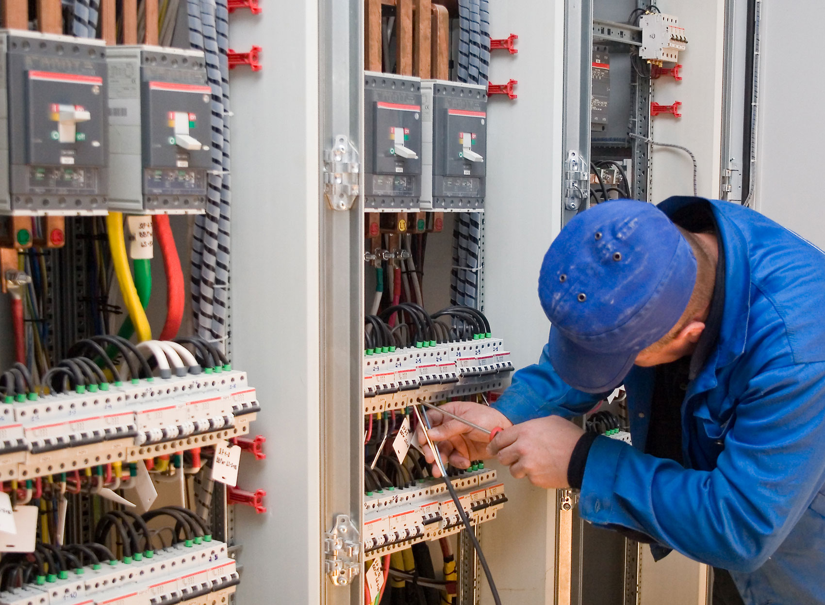 Ein Mitarbeiter von Elektrotechnik Genzverkabelt etwas an einem Schaltkasten.
