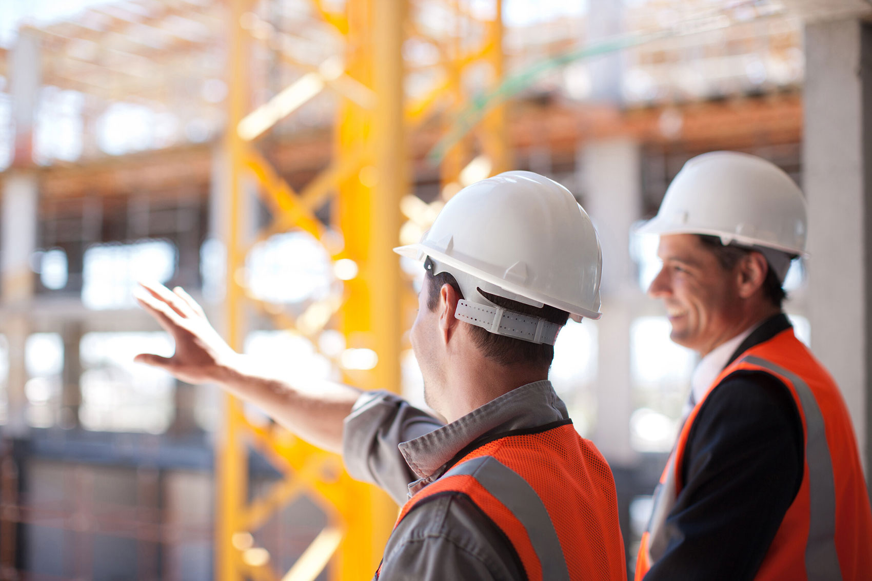 Zwei Mitarbeiter von G+N Consult auf der Baustelle mit Warnwesten und weißen Helmen