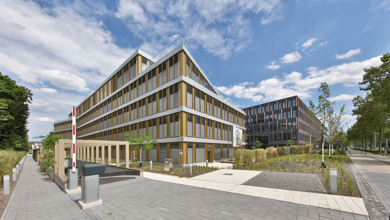 Gooneforty in Bonn: Fünfstöckiges Gebäude, senfgelbe Fassade mit horizontalen Metallpanelen.