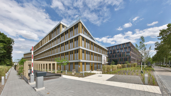 Gooneforty in Bonn: Fünfstöckiges Gebäude, senfgelbe Fassade mit horizontalen Metallpanelen.