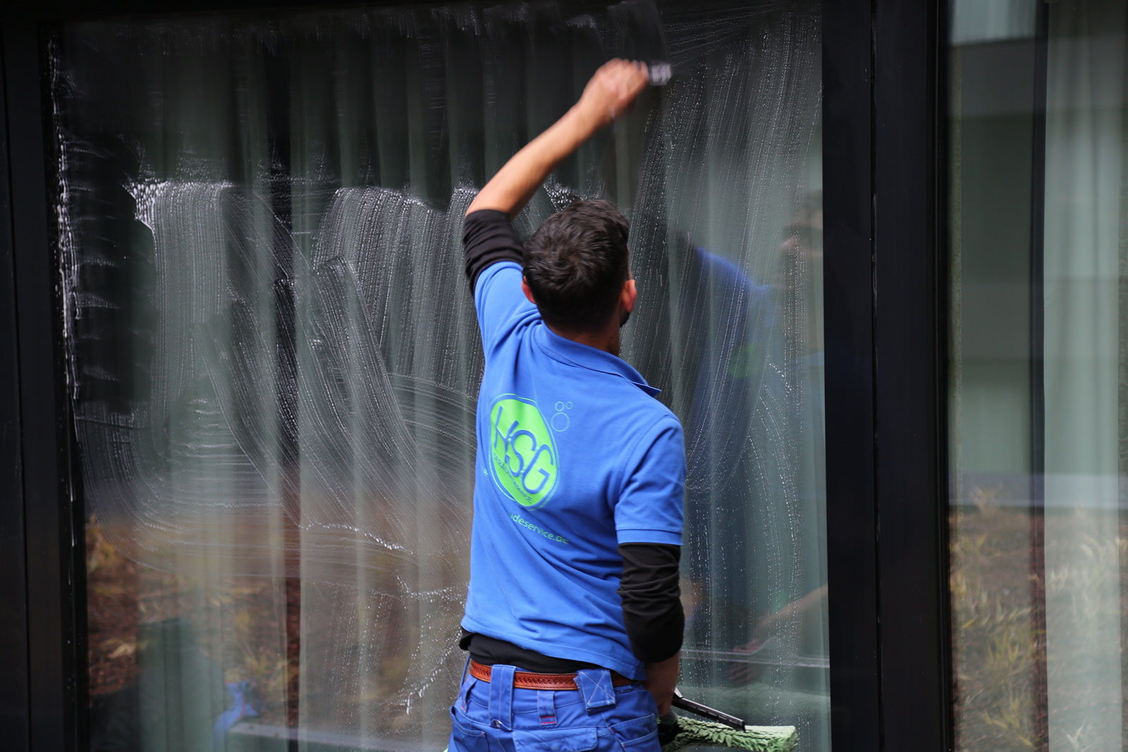 Mitarbeiter von HSG Gebäudeservice in blauen Arbeitsklamotten