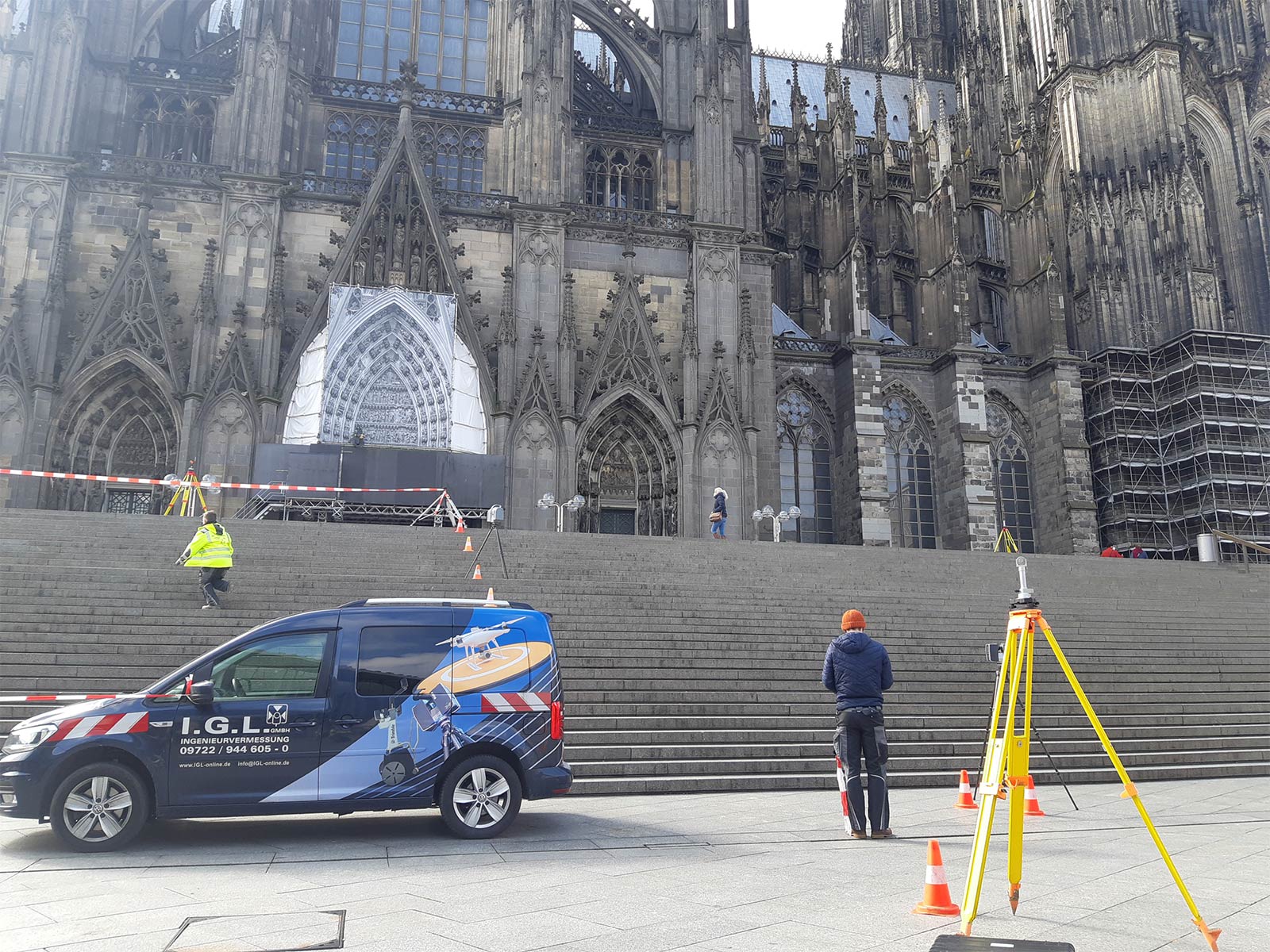 Zwei Mitarbeiter von I.G.L. stehen mit Messgeräten vor einer Kirche