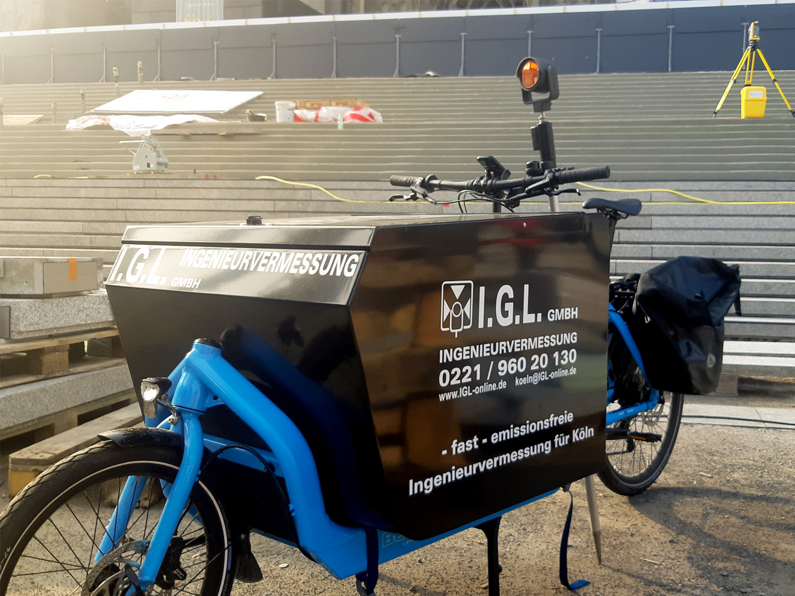 Blaues Lastenfahrrad mit aufgedrucktem Logo: I.G.L. GmbH Ingenieurvermessung