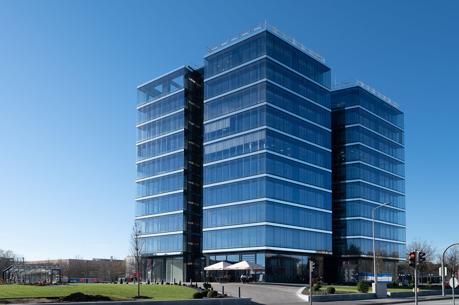 Foto des KARL-Turm in Deggendorf. Mit seiner blauen Glas-Fassade "verschwindet" er fast im Blau des Himmels.
