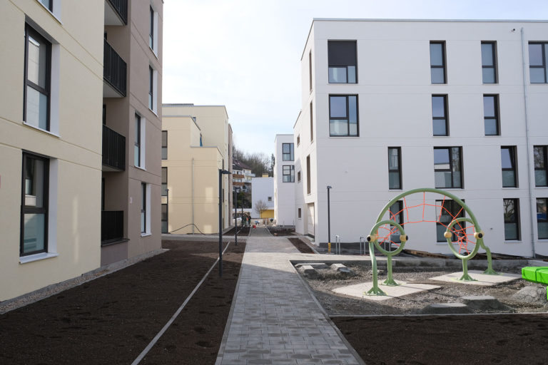 Erste fertiggestellte Wohngebäude der Keltersiedlung in Stuttgart Zuffenhausen. Sie sind bauhaus-artig modern gehalten und im Vordergrund ist ein kleiner Spielplatz erkennbar.