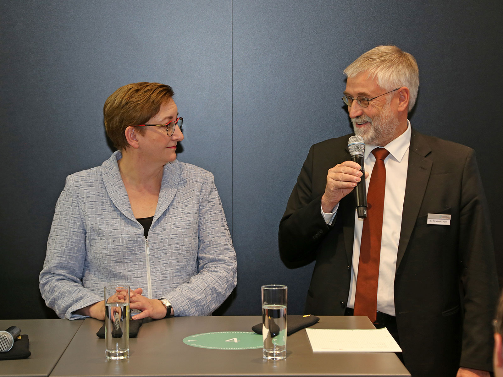 Bundesministerin Klara Geywitz und BImA-Vorstandssprecher Dr. Christoph Krupp stehen sich gegenseitig zugewandt an einem Podium.