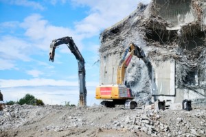 Zwei Abrissfahrzeuge bauen Betonstrukturen zurück.