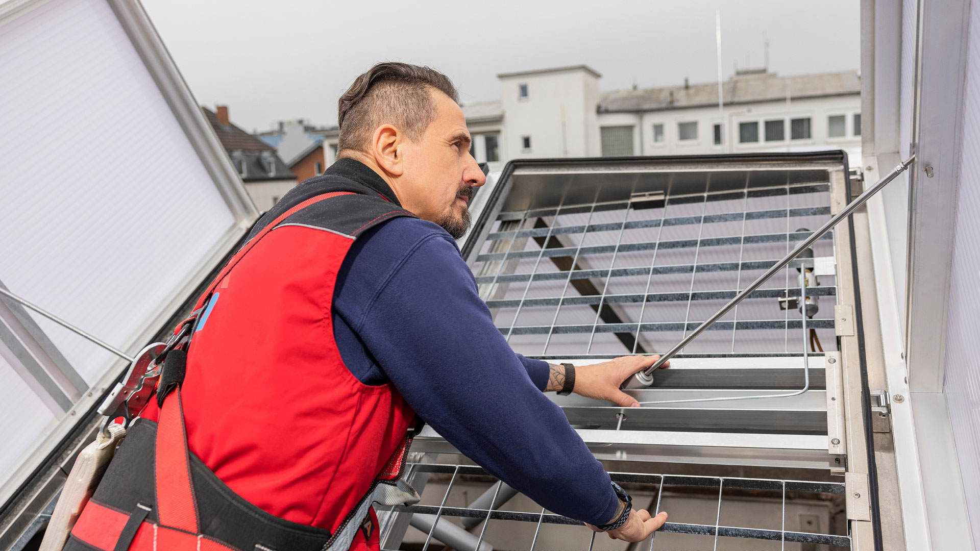LAMILUX-Mitarbeiter kontrolliert auf dem Dach eine Hydraulik für automatische Fensteröffnung