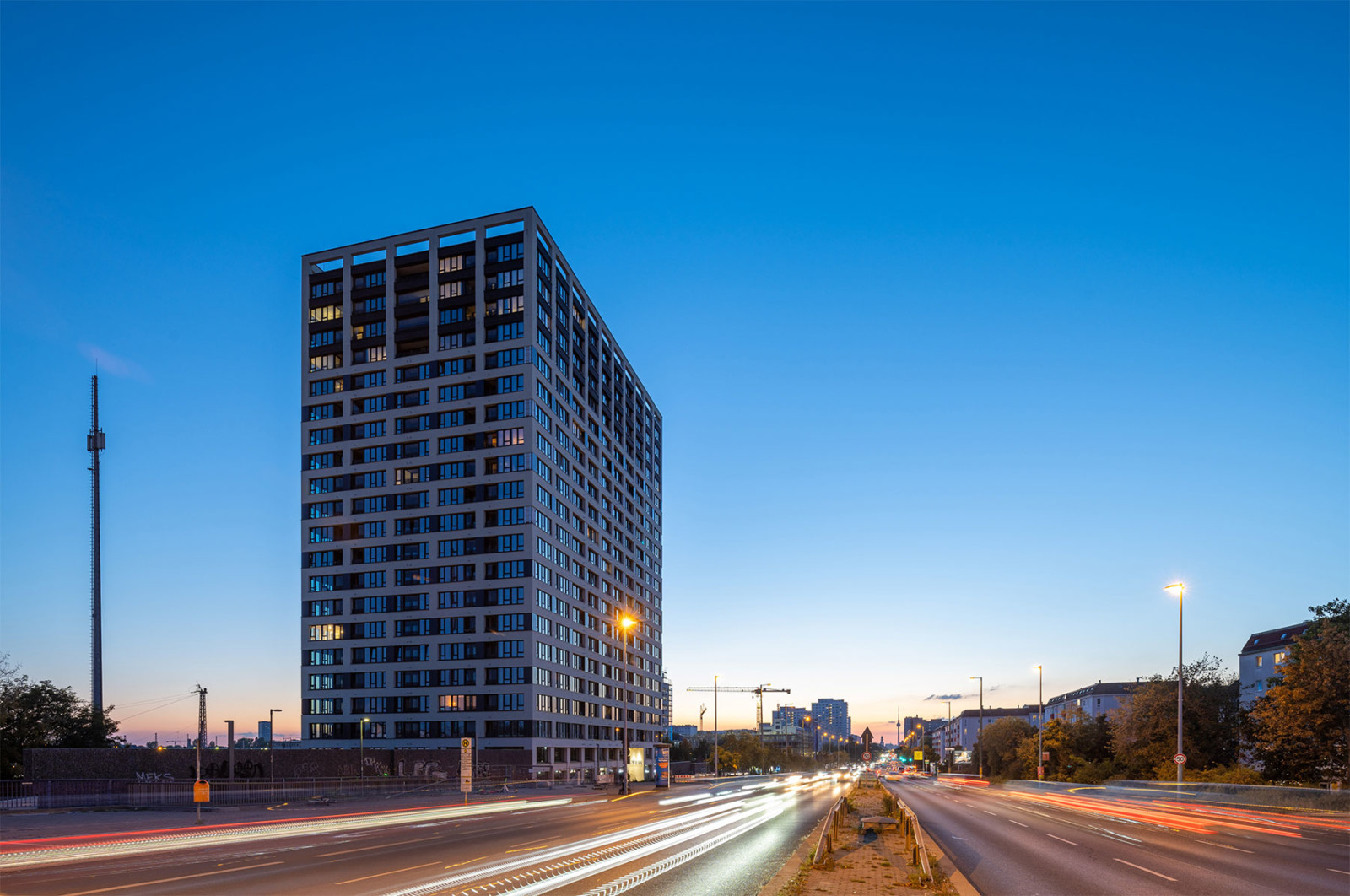 Wohnhochhaus LIESE in Berlin bei Sonnenuntergang mit blauem Himmel