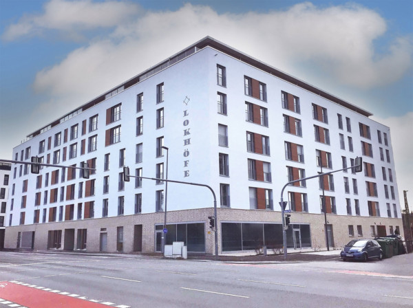 Das Studierendenwohnheim im neuen Stadtquartier LOKHÖFE Rosenheim: Siebengeschpssiges, rechteckiges Wohngebäude mit weißer Fassade.
