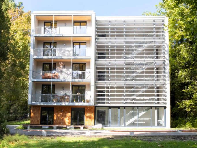 Die Anschlussunterbringung in der Luisenstraße Konstanz ist ein 5 stöckiges Gebäude mit hellen Holzschindeln und umgeben von Bäumen.