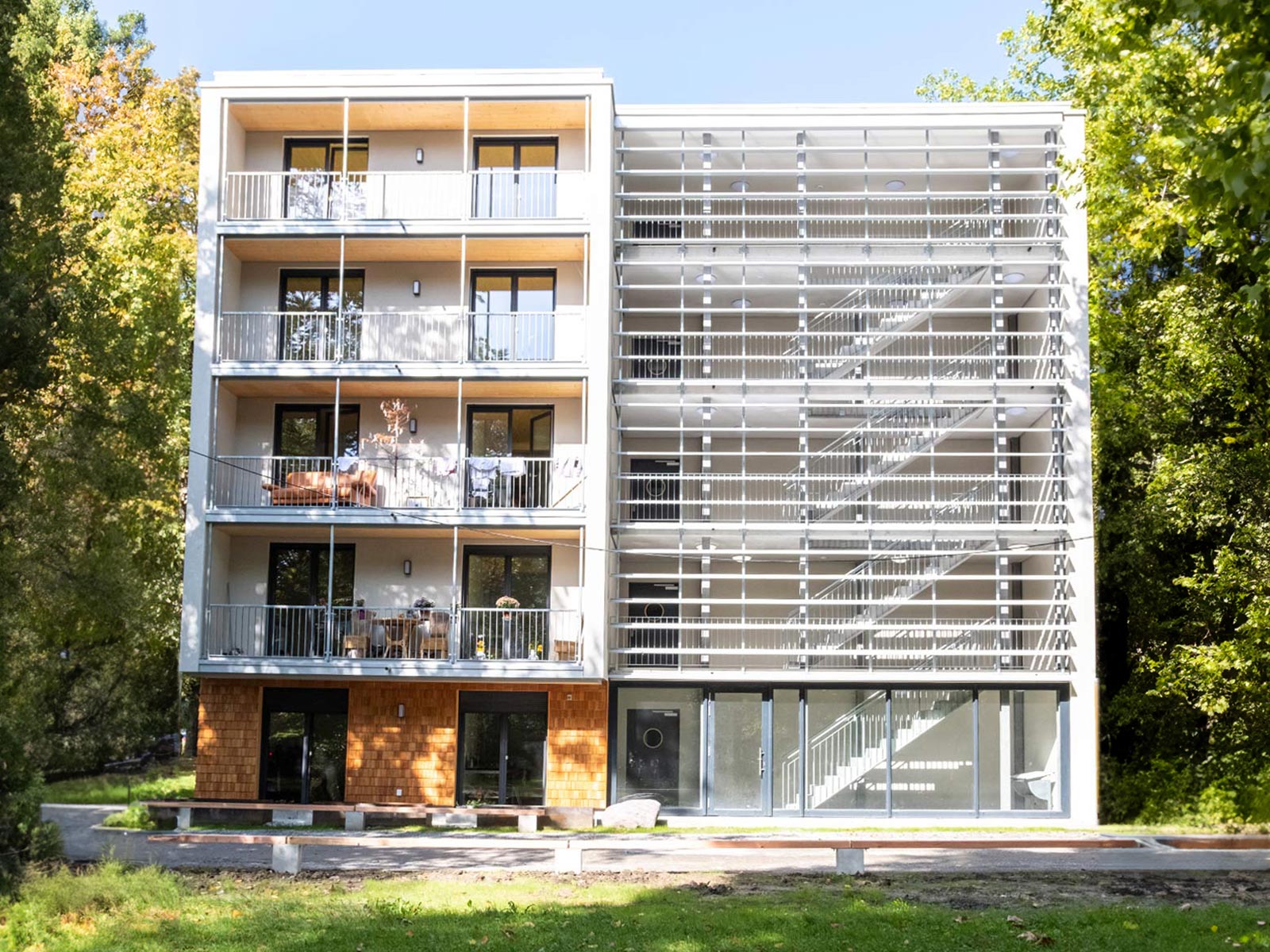 Die Anschlussunterbringung in der Luisenstraße Konstanz ist ein 5 stöckiges Gebäude mit hellen Holzschindeln und umgeben von Bäumen.