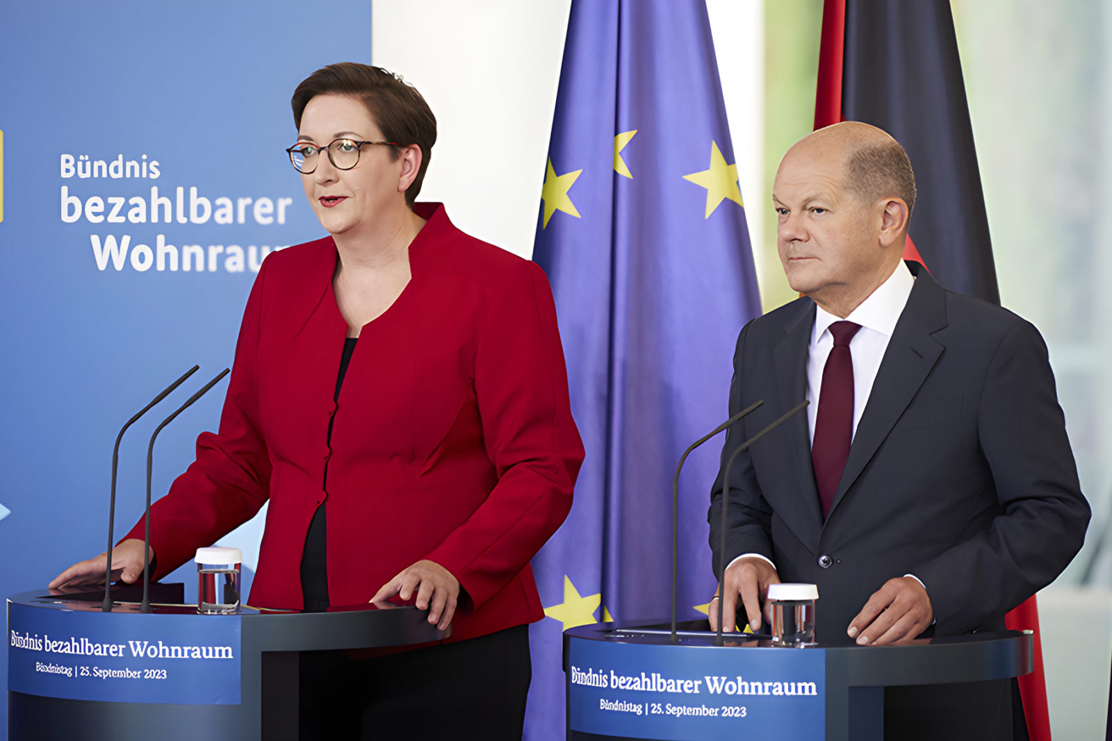Klara Geywitz und Olaf Scholz stehen an zwei Podien und sprechen über das Maßnahmenpaket für die Baubranche und Immobolienbranche.