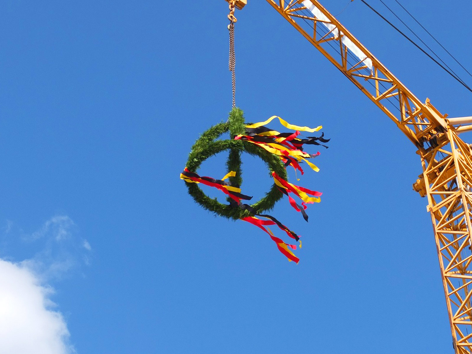 Auf dem Beitragsbild zum Richtfest des Neubaus am Eisenhutweg in Berlin-Johannisthal schwebt ein Richtkranz an einem Kran.