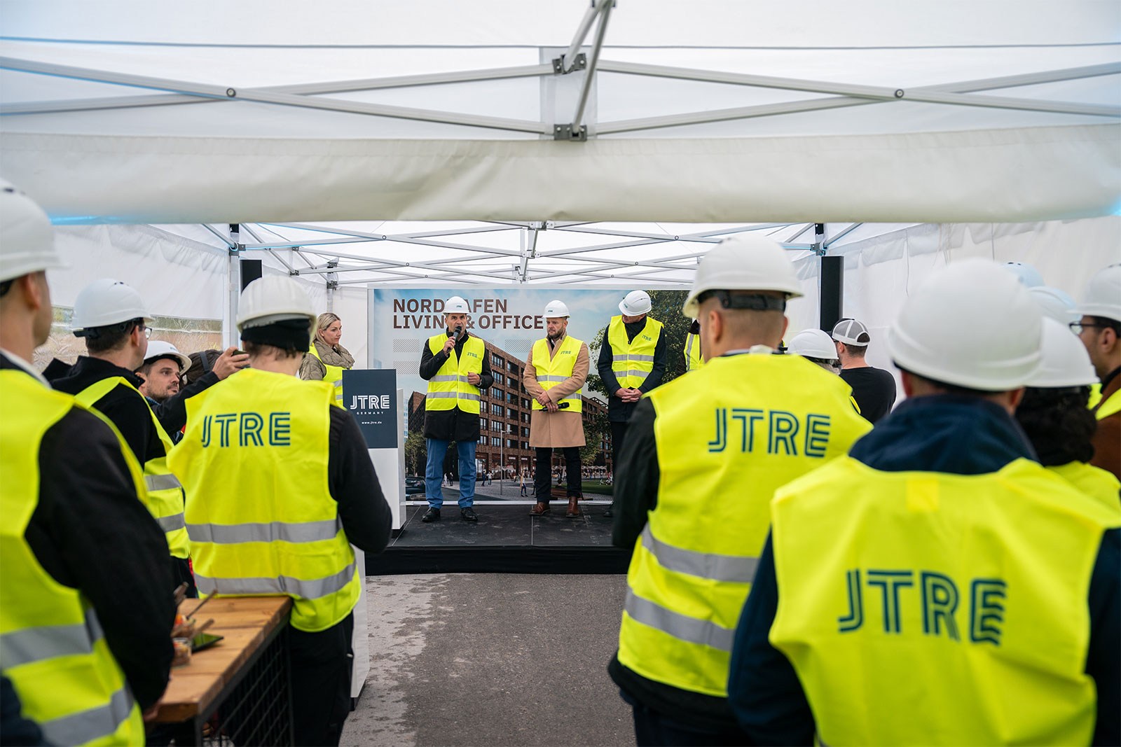 Viele Männer mit Warnwesten bei der Grundsteinlegung von Nordhafen Living & Office in Berlin.