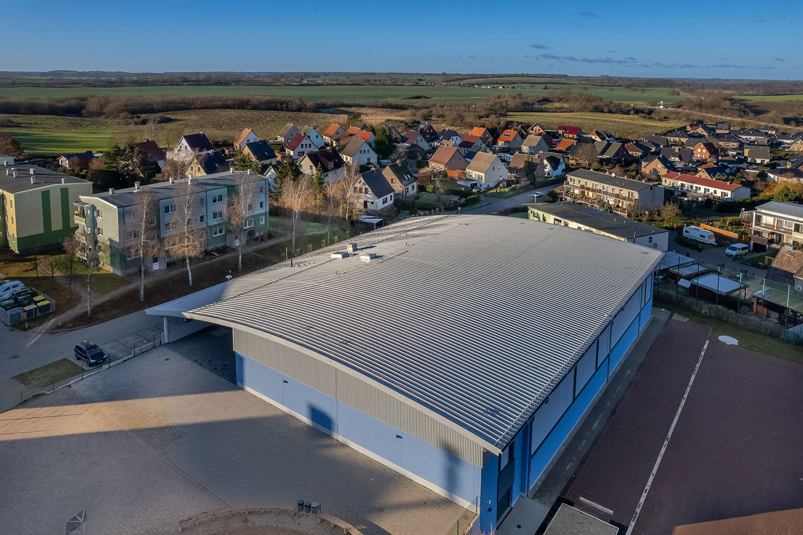 Eine Halle mit einem leicht nach unten abgerundetem Wellblechdach
