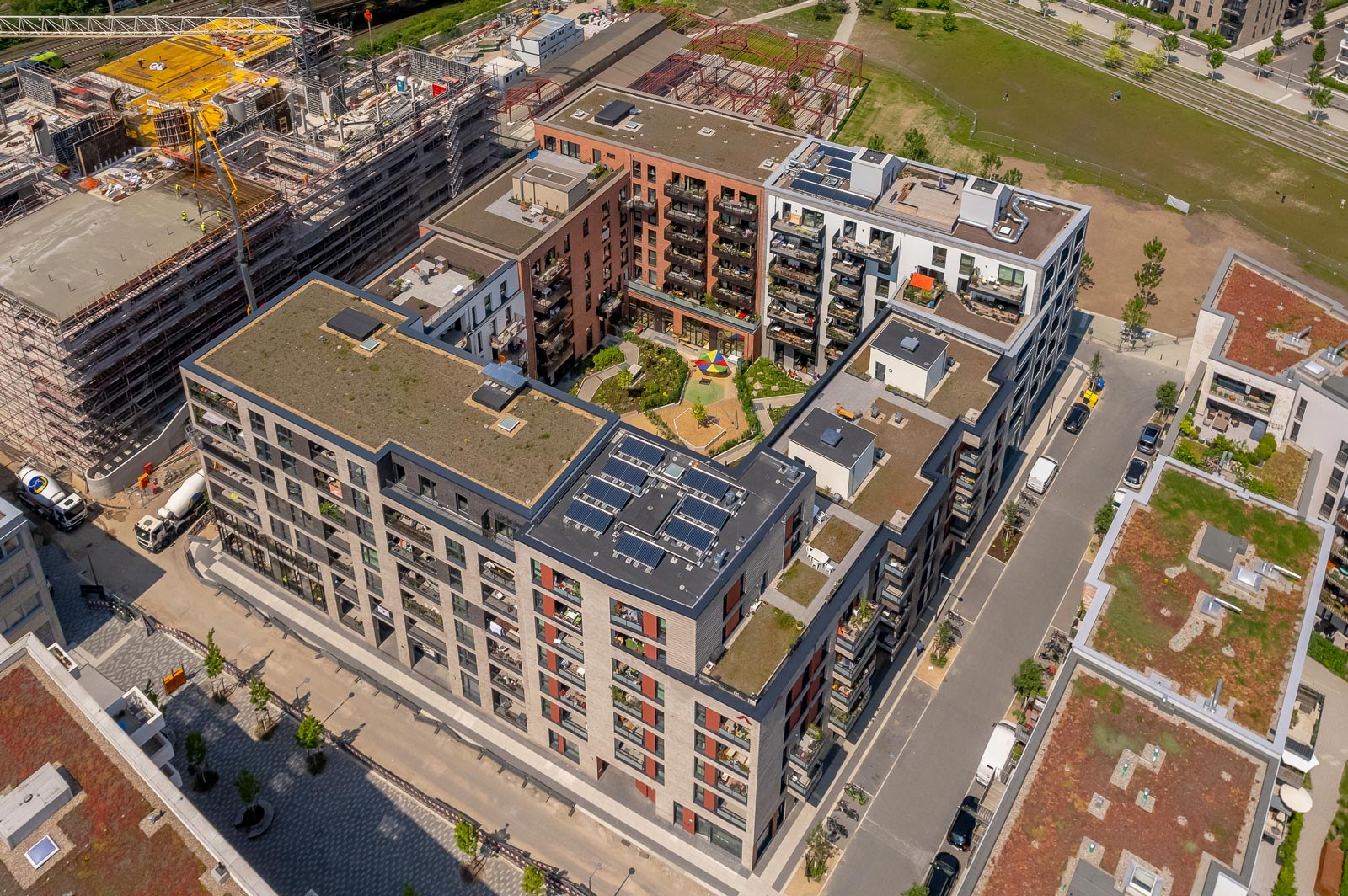 Rechteckig angeordnete Gebäude mit Innenhof von oben. Solarpaneele auf den Dächern