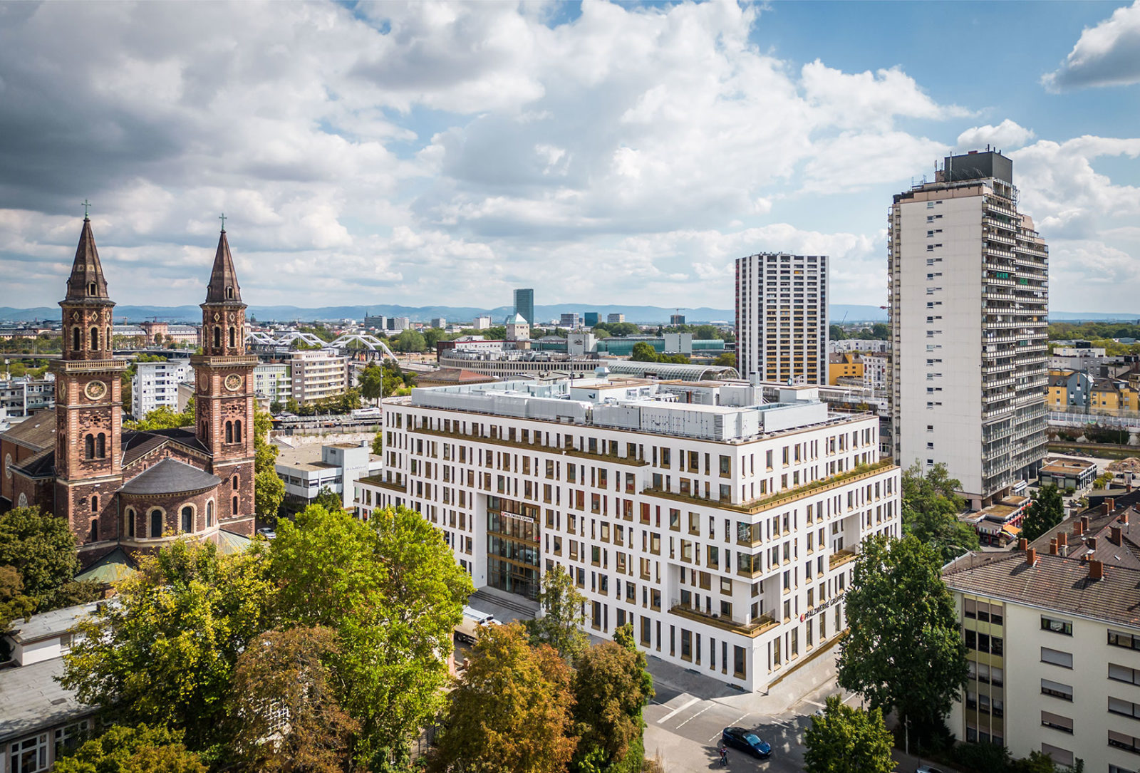 Der blockartige Neubau der Pfalzwerke Ludwigshafen hat eine weiße Fassade mit sehr vielen Fenstern und gold-braunen Fänsterrähmen.