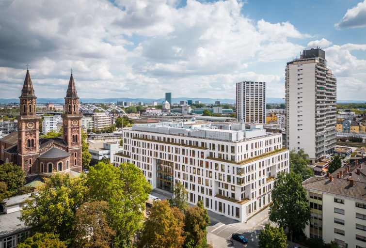 Der blockartige Neubau der Pfalzwerke Ludwigshafen hat eine weiße Fassade mit sehr vielen Fenstern und gold-braunen Fänsterrähmen.