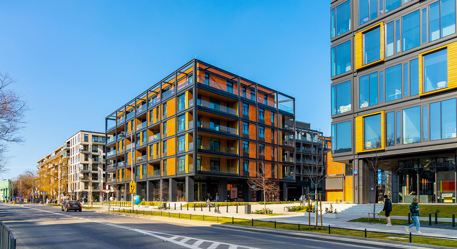 Wohnhaus mit organgefarbener Fassade und kastenartigem Stahl-Gerüst außen herum