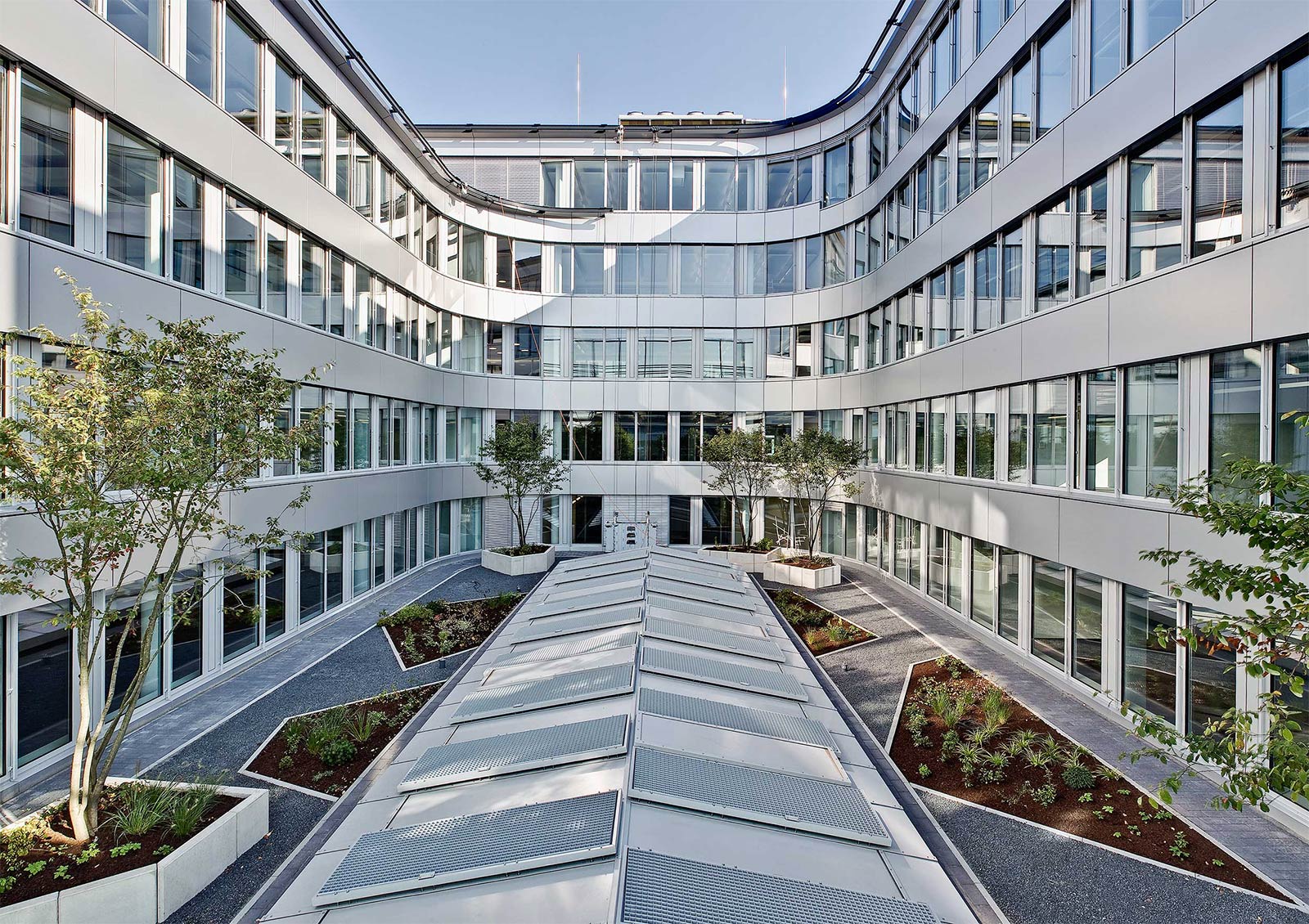 Profilbild der Alubau Puhlmann GmbH & Co. KG: Blick aus dem Innenhof auf eine Fassade aus Aluminium.