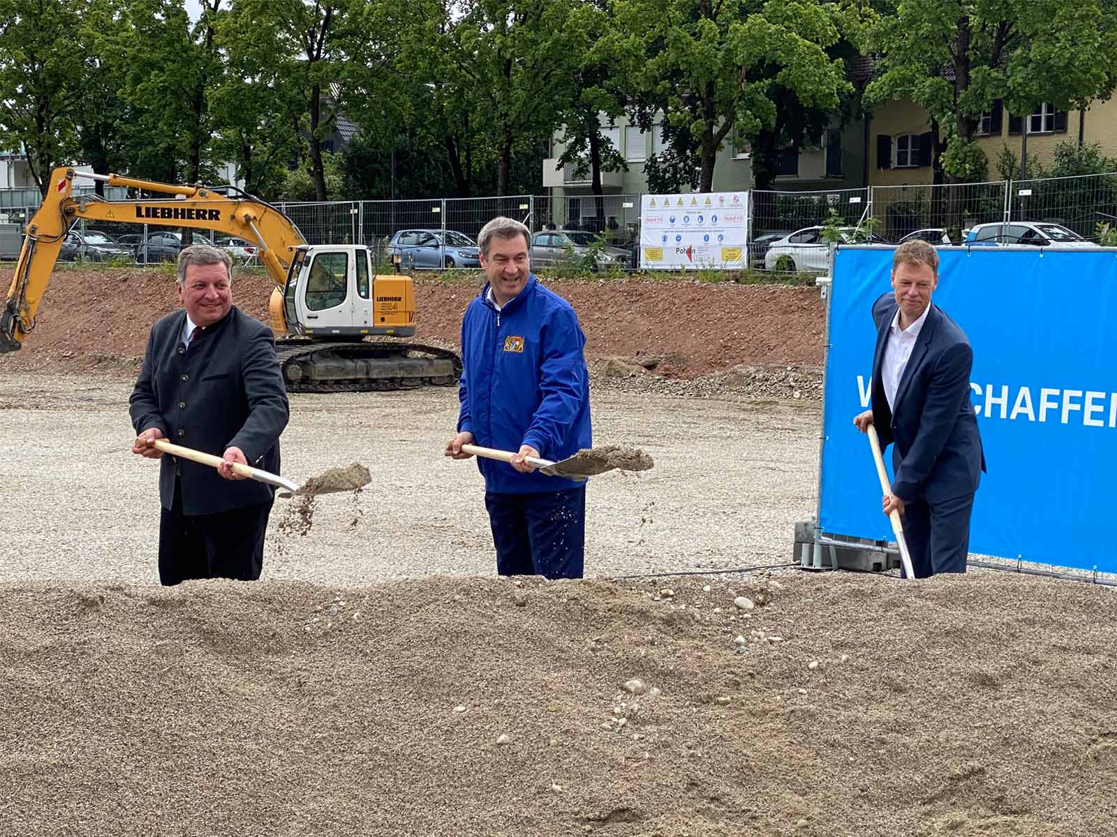 Drei Männer schaufeln Sand zum Richtfest des Neubaus auf dem ehemaligen Gelände der McGraw Kaserne in München.