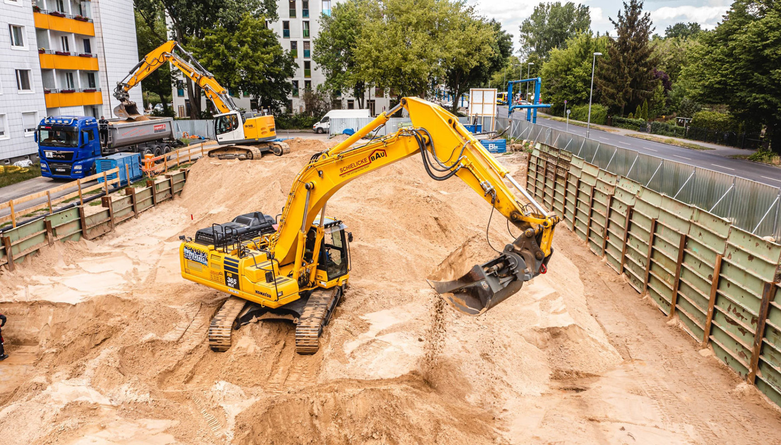 Gelber Bagger mit dem Logo von Schielicke Bau