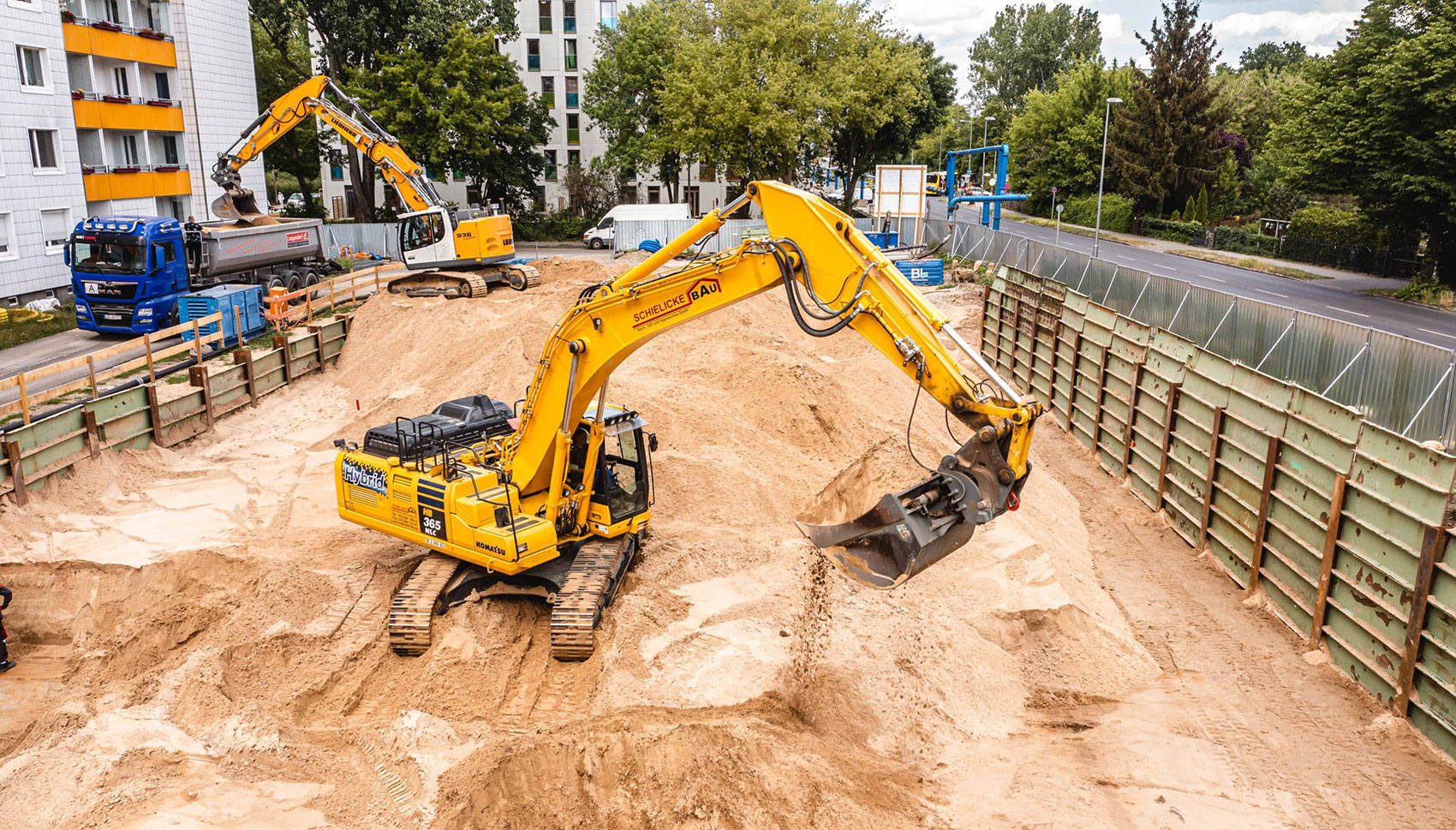 Gelber Bagger mit dem Logo von Schielicke Bau
