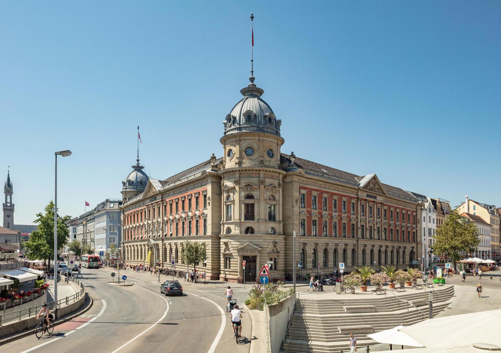 Der imposante Altbau der Sparkasse Altbau besteht aus Sandstein und hat zwei Türme mit Kuppeldächern an zwei Ecken.