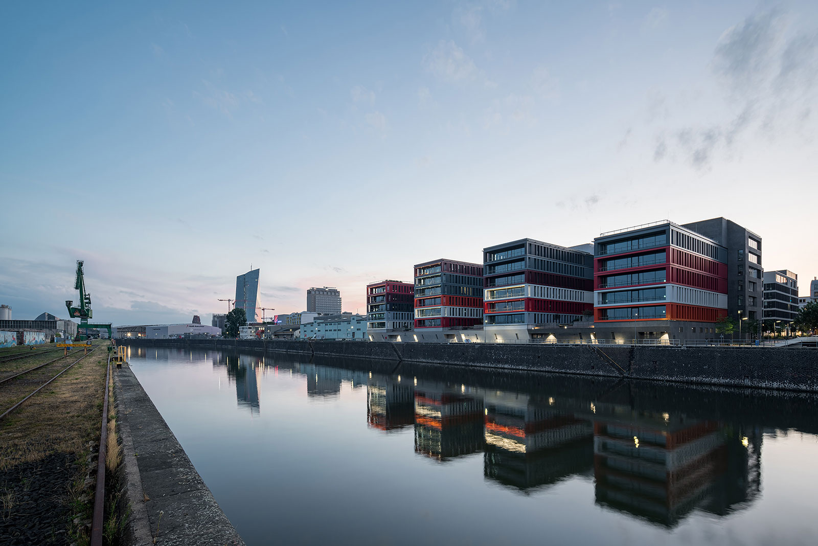 The DOCKS Frankfurt: Die Gebäude spiegeln sich im Flusswasser und ähneln gestapelten Containern