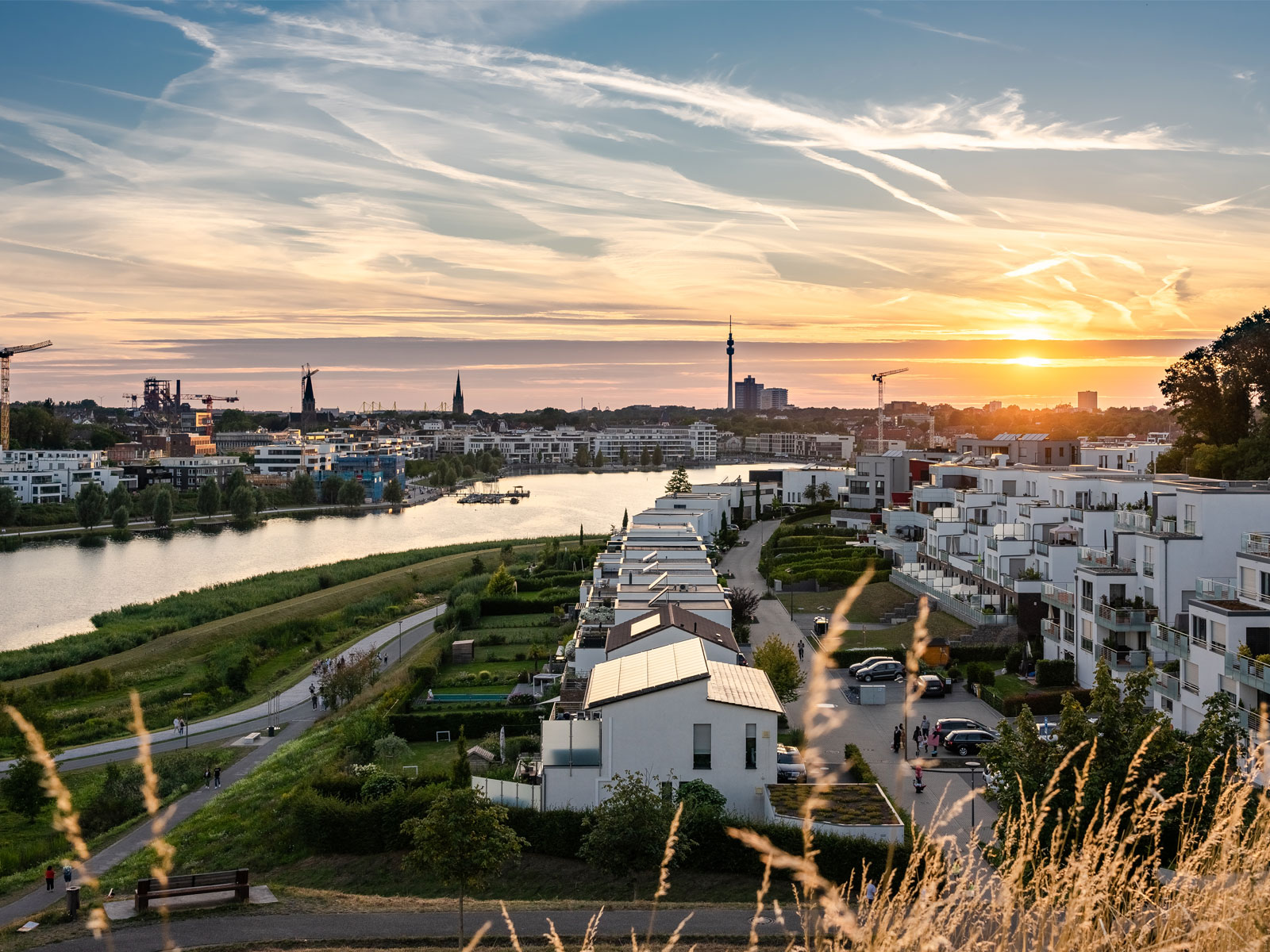 Titelbild zum Beitrag Urbane 34 zeigt den Phönixsee und Skyline Dortmunds im Sonnenuntergang.
