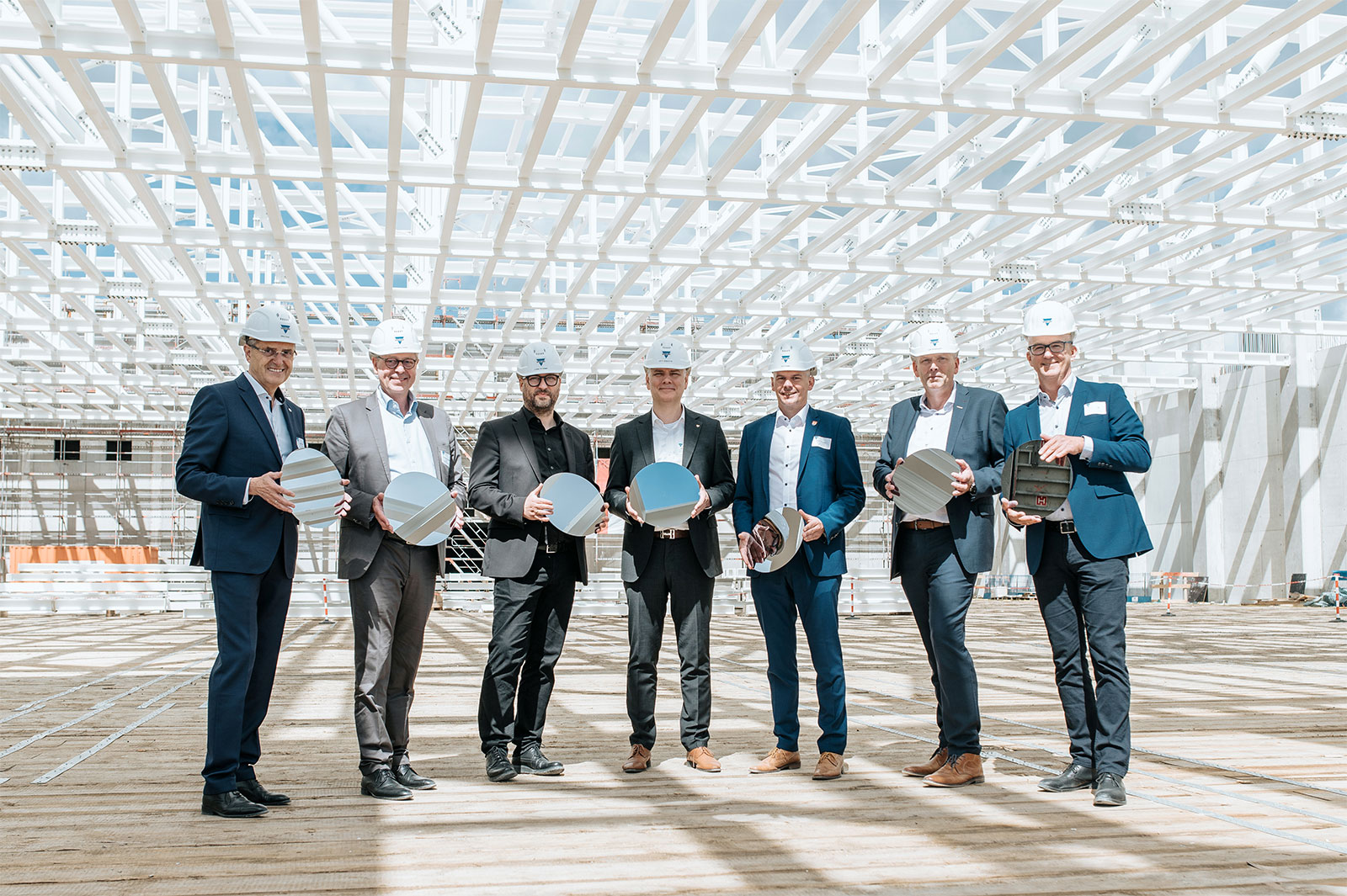 7 Männer beim Richtfest der Chipfabrik für Halbleiter in Itzehoe.