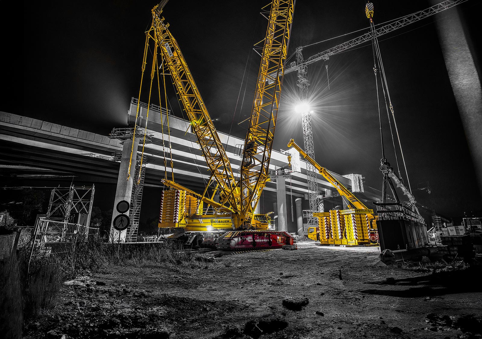 Auf dem Profilbild der Wiesbauer GmbH & Co. KG in Bietigheim-Bissingen zeigt einen gelben Autokran bei Nacht.