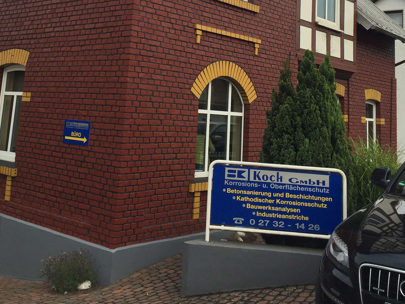 Züblin übernimmt Koch GmbH: Haus mit dem Unternehmensschild der Koch GmbH im Vordergrund